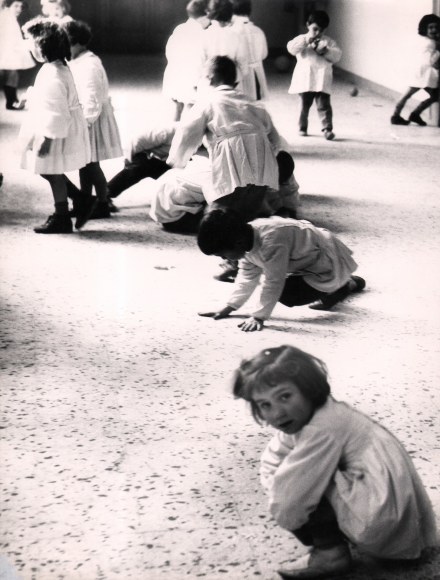 25. Renzo Tortelli, Piccolo Mondo, 1958&ndash;1959. High contrast image. Children crouched in a row and one moving between them as to play a game of leap frog.