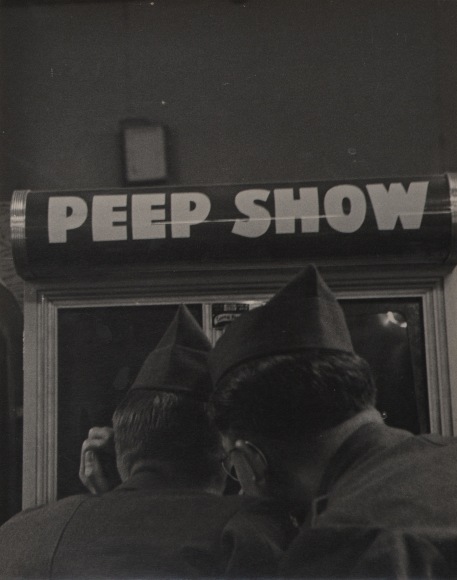 46. Simpson Kalisher, Untitled, ​1952. Two men in army uniform photographed from behind looking through a window marked &quot;Peep show&quot;