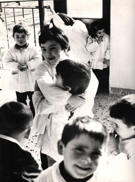 26. Renzo Tortelli, Piccolo Mondo, 1958&ndash;1959. High contrast image. Two children embrace in the middle of a group of playing children.