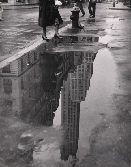 51. Bedrich Grunzweig, April Shower, ​1951. Reflection of a skyscraper in a puddle on the city street.