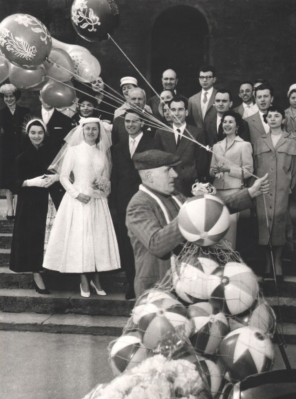 Nino Migliori, Gente dell'Emilia, ​1952. A group poses for a wedding portrait as a balloon vendor walks through the foreground.