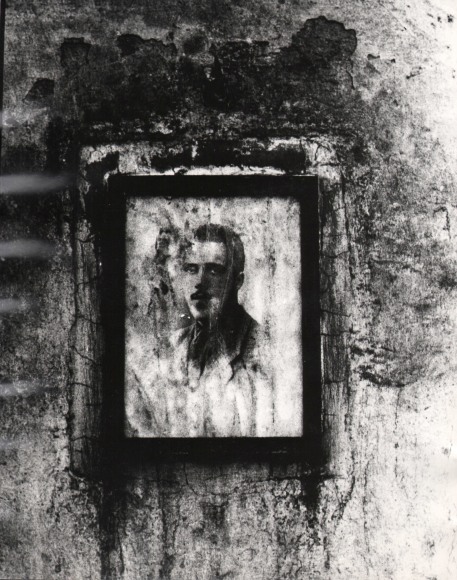 Mario Carrieri, Milano, ​c. 1958. A weathered portrait in a black frame hangs on an equally worn wall.