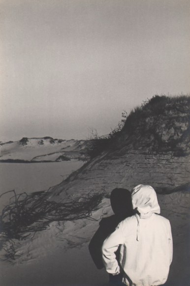 PaJaMa, Paul Cadmus, Margaret French, ​c. 1945. Two hooded figures, backs to the camera, look out from the lower right of the frame towards sand dunes.