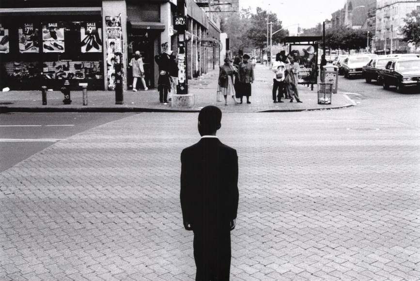 16.&nbsp;Church Boy: A boy stands on the corner of 125th Street and Adam Clayton Jr. Boulevard a moment before he crossed on his way to church at the United House of Prayer For&nbsp;All People, June 1994.