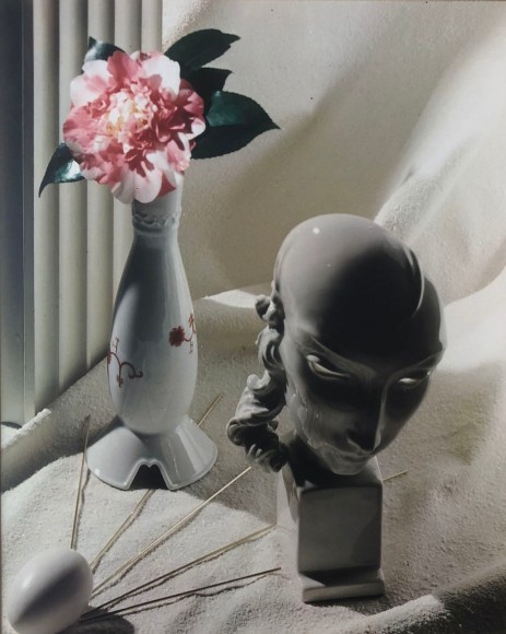 Hi Williams, Untitled, ​c. 1937. Mostly white composition with a marble head sculpture, a vase with a pink flower, and an egg on white fabric.