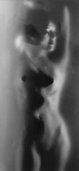 Ruth Bernhard, Luminous Body, ​1962. Nude female figure pressed against glass, facing the camera and lit from the right.