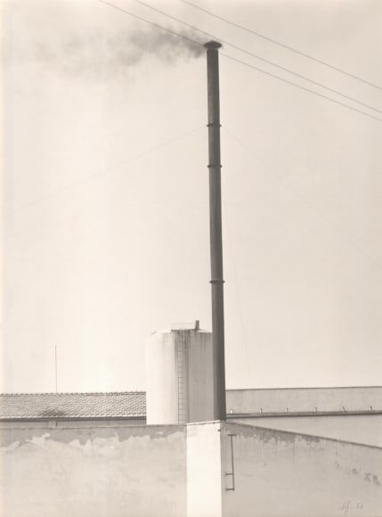 Alberto Galducci, Untitled, ​n.d. Rooftop with tall, thin smokestack protruding upward to divide the frame vertically.