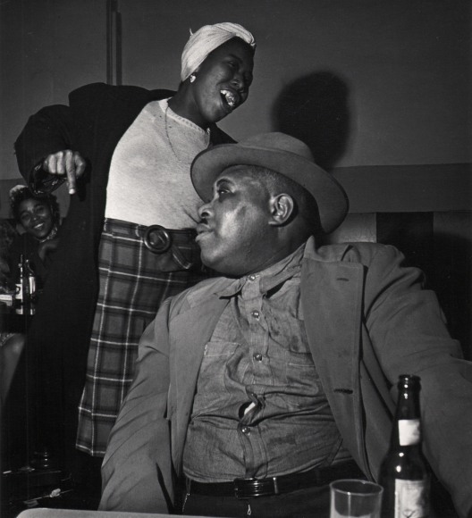 Wayne Miller, Untitled, Chicago, ​1946&ndash;1947. A seated man looks to the left while a woman smiles, looking to the right, standing behind him.