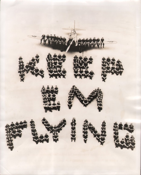 40. Southeast Air Corps Training Center, The human side of America's well-known defense challenge is shown here by Flying Cadets in the Southeast Air Corps Training Center, who have arranged themselves on the apron in front of a Maxwell Field hanger...,​ August 11, 1941. Men photographed from above have been arranged to form the phrase &quot;Keep em flying&quot;