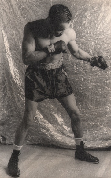 Carl Van Vechten, Henry Armstrong, ​1937. Subject holds a boxing pose in front of a reflective backdrop.