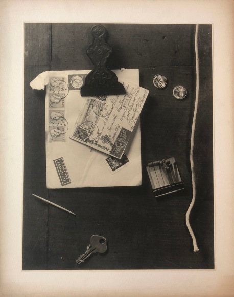 Kenneth Heilbron, Trompe L'Oeil, ​c. 1954. Still life featuring a postcard and envelope, a key, toothpick, pennies, matches, and string against a wooden surface.