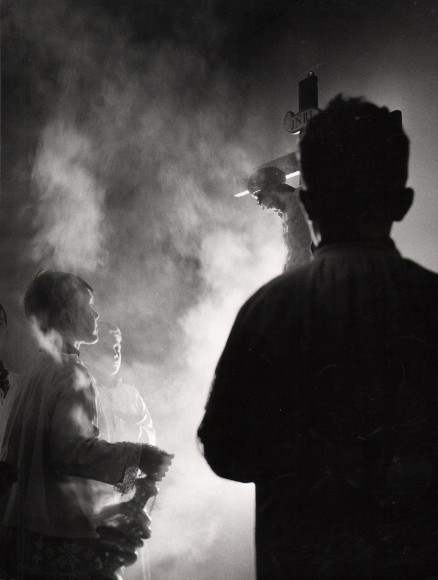 Carlo Bevilacqua, Venerdi Santo, ​c. 1955. Dark, smoky scene with three young boys surrounding a large crucifix.