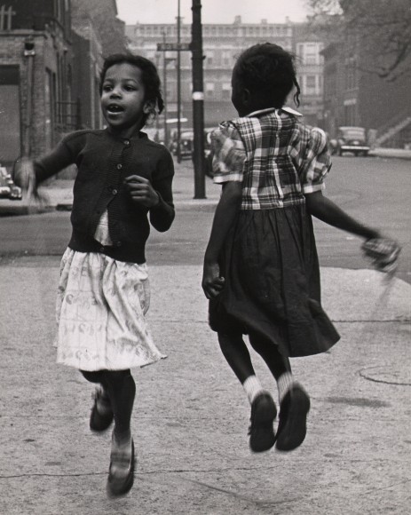 Marvin E. Newman, Chicago, ​1950. Two young girls jump rope on the sidewalk, one facing the camera, one away.