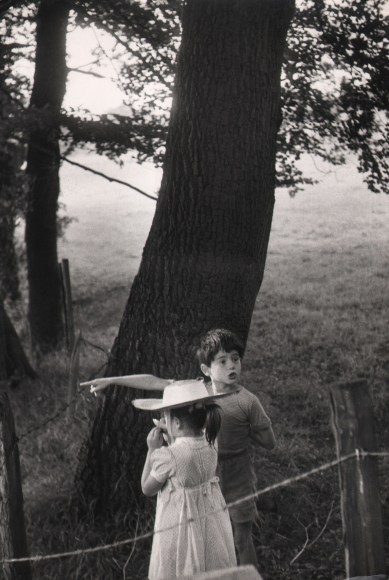 44. Thurston Hopkins, The secret games of children, c. 1957. A young boy and girl stand beneath a tree, the young boy pointing to the left of the frame.