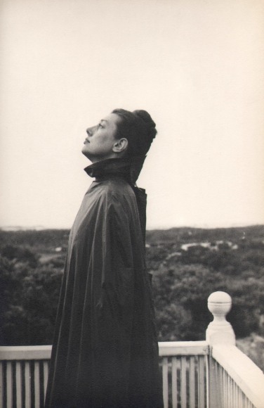 PaJaMa, Fidelma Cadmus, Nantucket, ​c. 1945. A woman stands facing left, looking upward, at the corner of a low white railing.