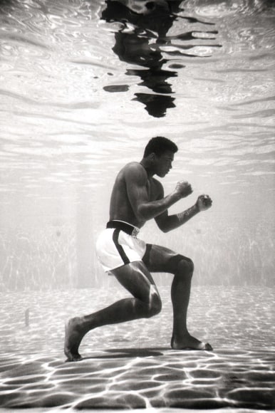 Flip Schulke, Ali Underwater, ​1961. Subject holds a boxing pose, pictured in profile at the bottom of a swimming pool.