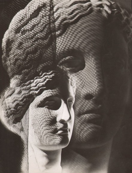 Claude Tolmer, Composition, ​1936. Marble sculpture of a woman's head in two overlapping views. Mesh netting casts a shadow.