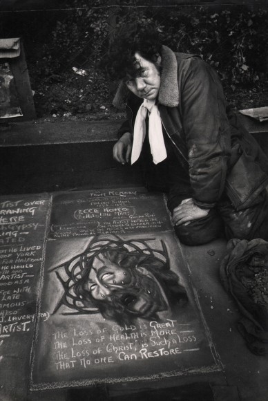 39. Brian Seed, Untitled, c. 1956. A man kneels by a religious chalk drawing featuring a crying Christ in a crown of thorns.
