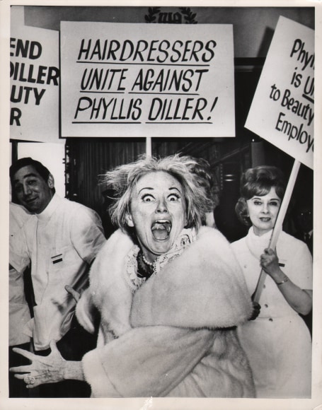 47. UPI Photo, &quot;In Fright,&quot; New York, ​April 18, 1967. A sign reads &quot;Hairdressers unite against Phyllis Diller!&quot; above Diller looking to the camera with a frightened expression.