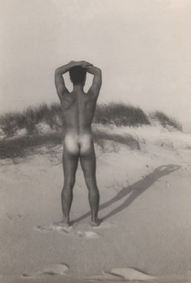 PaJaMa, Jos&eacute; Martinez, ​c. 1945. Nude male figure stands on the beach with arms resting across the top of his head, back to the camera.