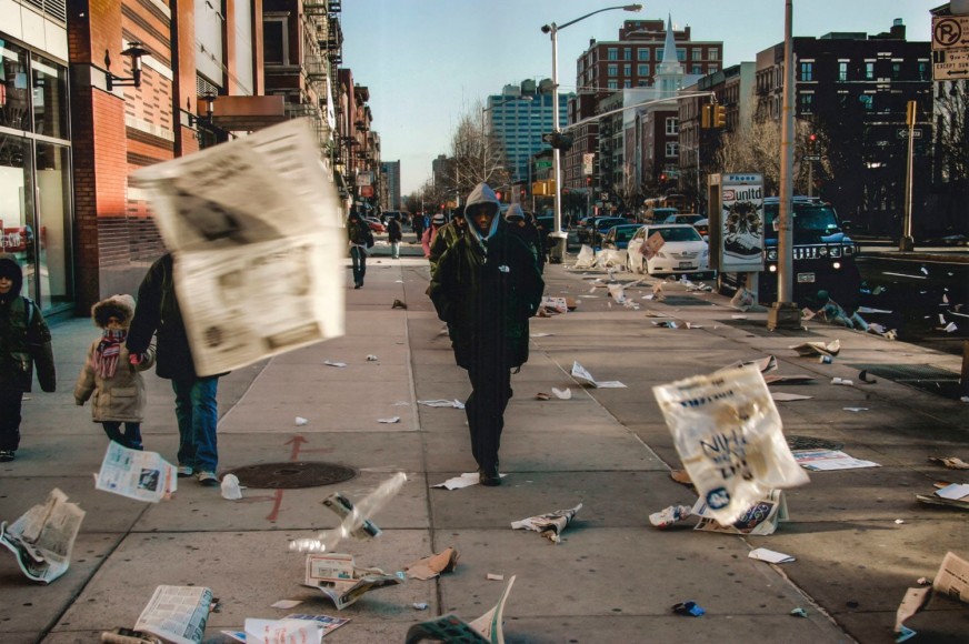 17. Blown Headlines: High winds blow loose newspaper pages around 125th street in Harlem near the IRT Subway entrance as some people make their way to work that morning, 2006.