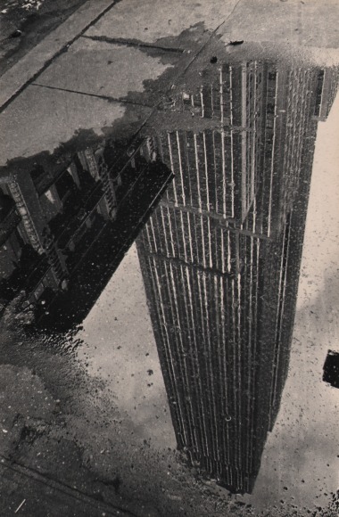 9B. Fritz Neugass, Reflections: Empire State in a Rain Puddle, c. 1948. Skyscraper reflection (upside-down) in a puddle on the sidewalk.
