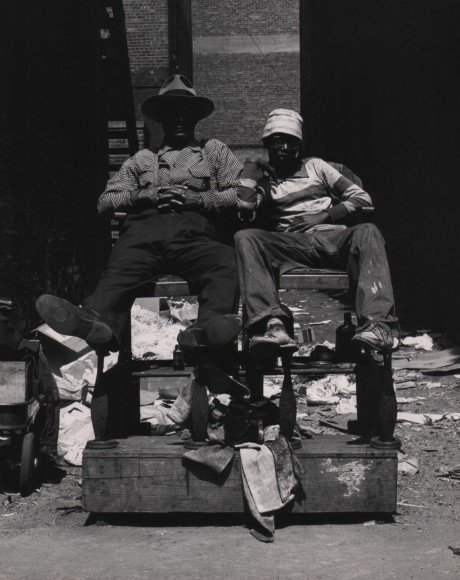 Marvin E. Newman, Chicago, ​1950. Two men, faces mostly in shadow, sit on a wooden set of steps on the street.