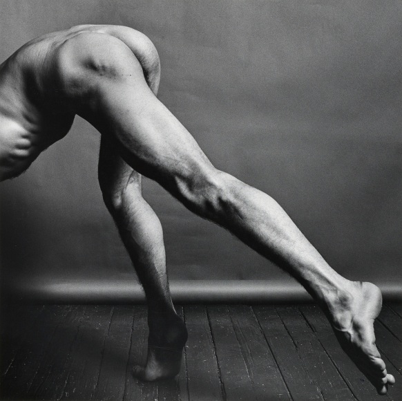 Nude dancer bending down, head out of frame.