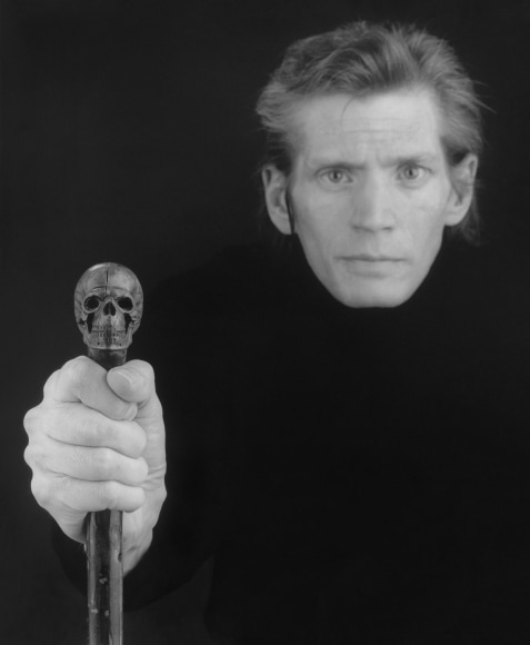 Self-Portrait of artist holding skull cane.