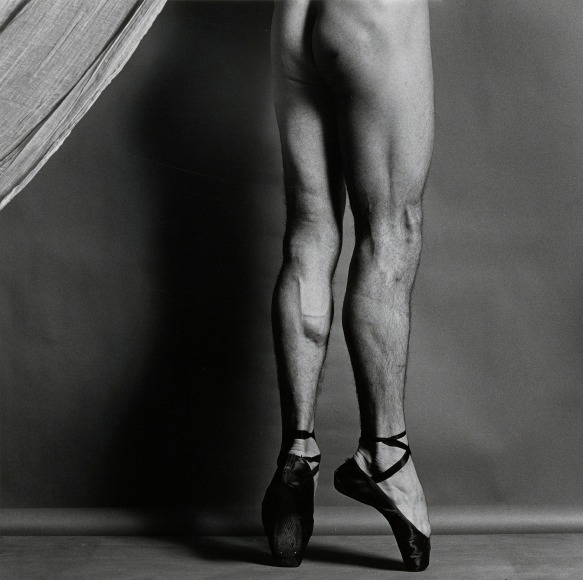 Nude dancer from the waist down except for pointe shoes, facing away from camera.