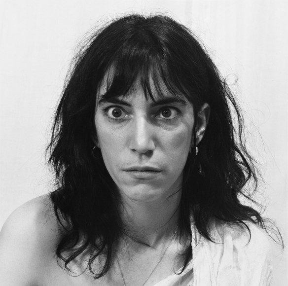 Patti Smith with eyes crossed, shirt falling off one shoulder.