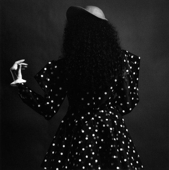 Woman in polka dot dress facing away from the camera.