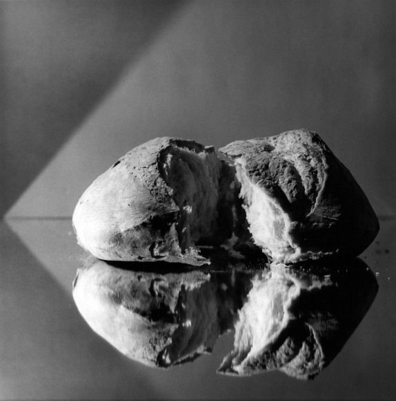 Loaf of bread sitting on a reflective surface.