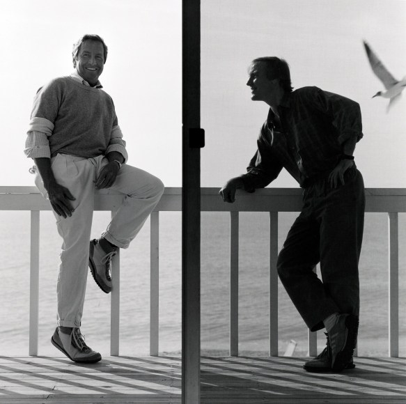 Robert Rauschenberg and another man standing on a balcony above water.