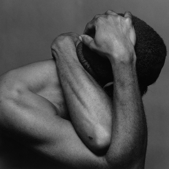 George Bussey holding his head with both hands, face not visible.