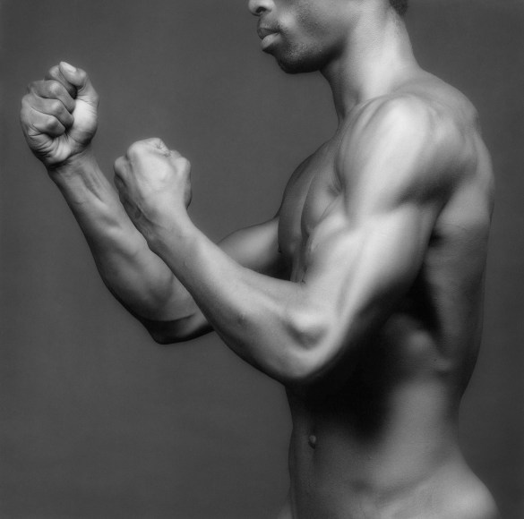 Dennis Speight in profile, holding up both hands in fists.