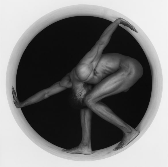 Black male nude posing in a circle.