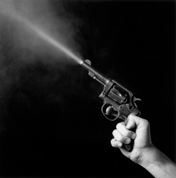 Hand firing gun upwards.