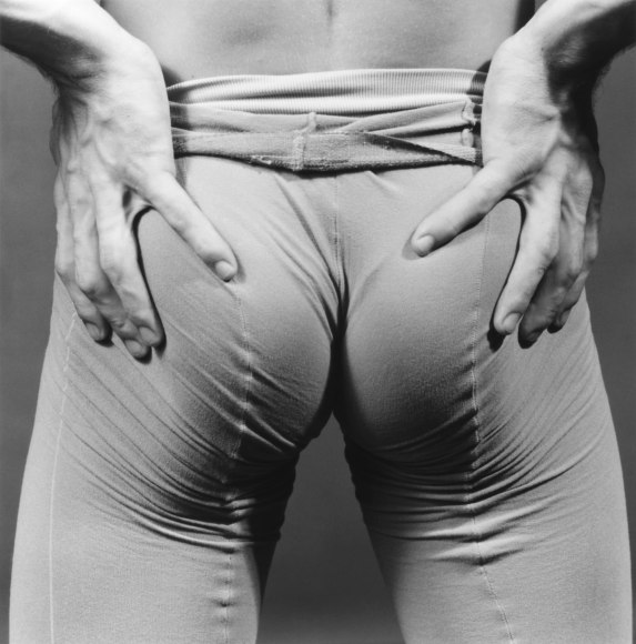 Hands holding butt, in tights.