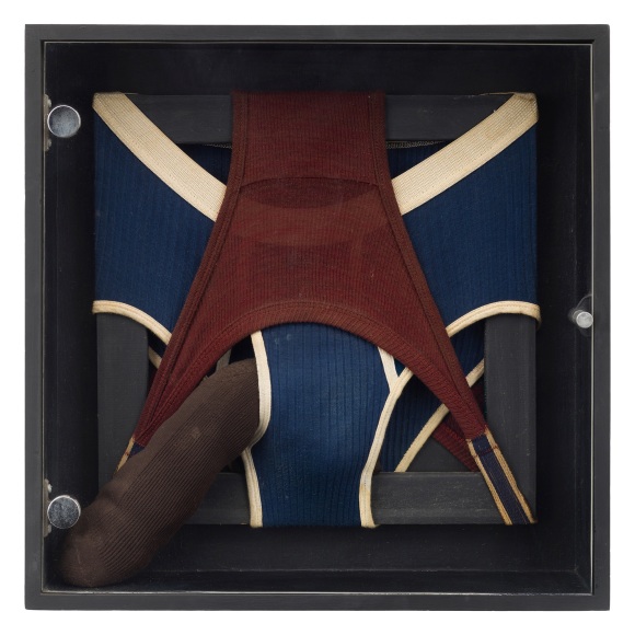 A red pair and a blue pair of mens underwear stretched around a black frame. A stuffed sock peeks out of the front of the blue pair of underwear.