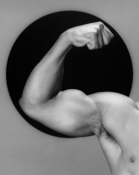 Vibert's arm flexing in front of black sphere.