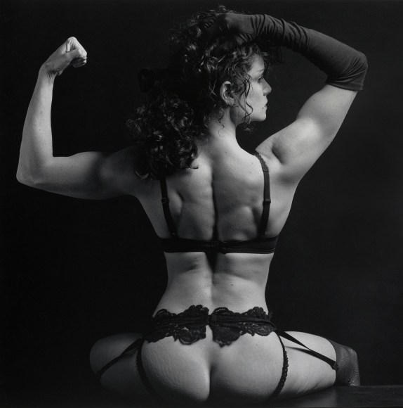 Lisa Lyon with back toward camera, wearing lingerie.