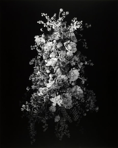Large bouquet of flowers of varying types against black background.