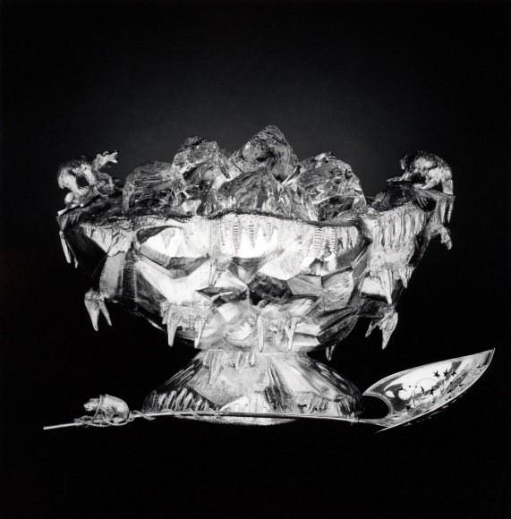 Silver ice bucket and spoon centered in image with black background.