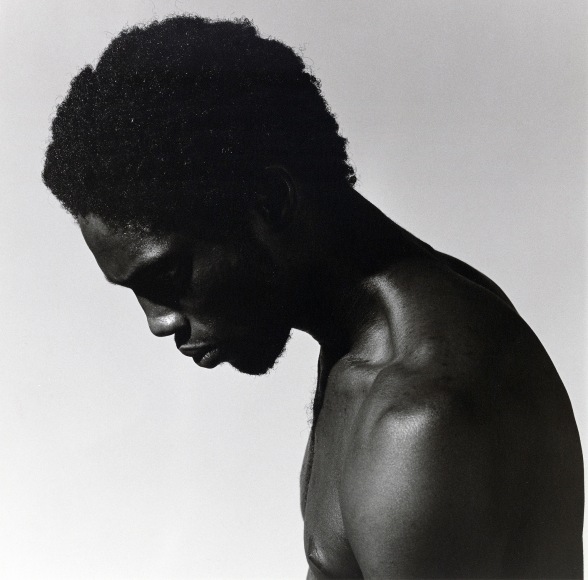 Alistair Butler in profile view, shirtless, looking down.