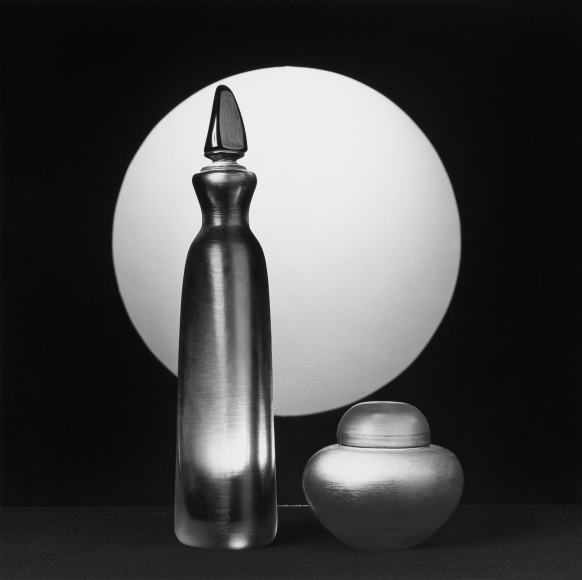 Two glass items with white sphere in background.