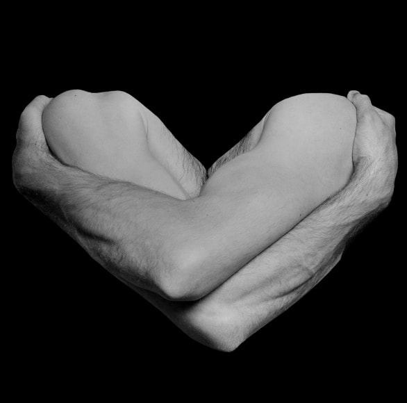 Two arms in shadow forming the shape of a heart.