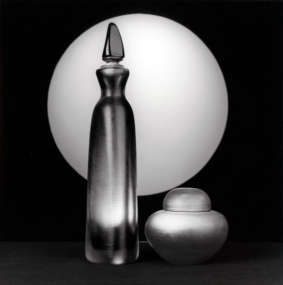 Two glass items with white sphere in background.