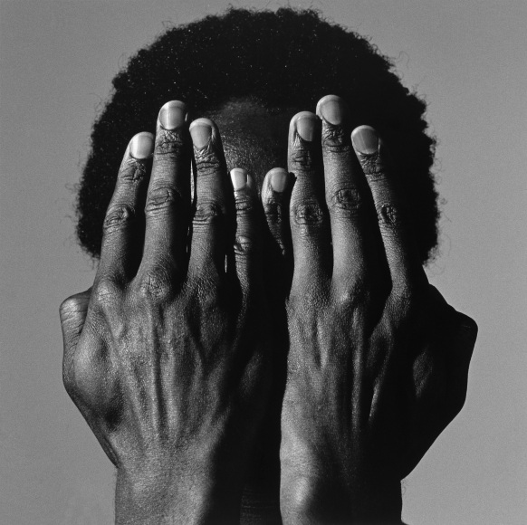 Alistair Butler covering face with both hands.