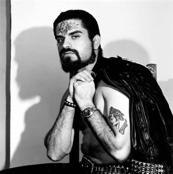 Man wearing leather with tattoos.